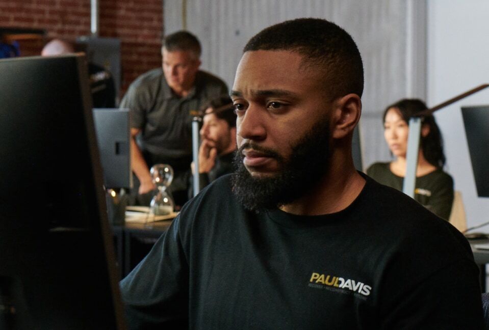 Paul Davis Restoration staff member assisting a customer at a computer in the office